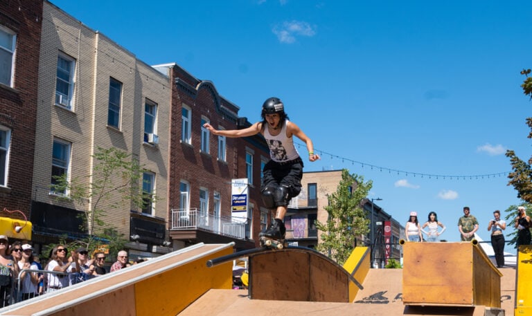 Roller skater performing a soul trick on a rail.
